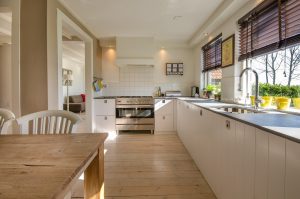 Cozinha grande com pia, mesa e armários protegida por uma Porta Blindada Residencial